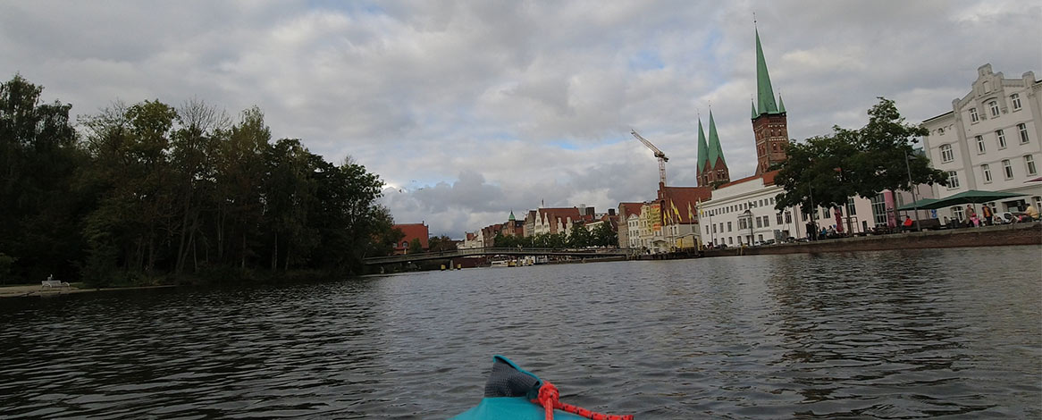 Blick auf die Lübecker Altstadt vom Kanu aus mit Kirchtürmen und Obertravebrücke