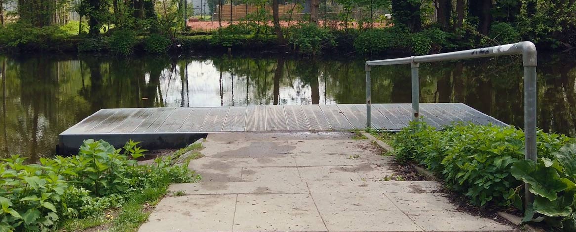 Öffentlicher Steg als Kanueinlass am Gewerkschaftsweg in Bergedorf mit gepflasterter Zuwegung für Fußgänger und Metalgelände