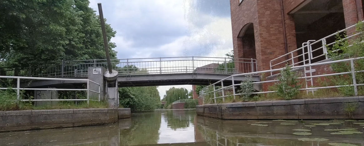 Fleetanlage am Allermöher Bahnfleet und Blick auf Metallbrücke im Hintergrund bei Kanutour aus dem Boot heraus fotografiert