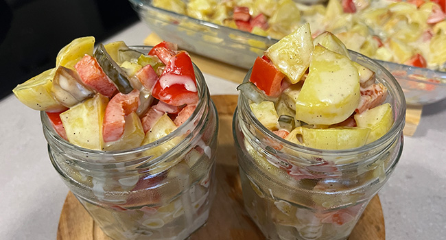 Vorschaubild zu veganem Country-Kartoffelsalat mit Kartoffeln und roter Paprika in zwei To-go-Gläser abgefüllt.